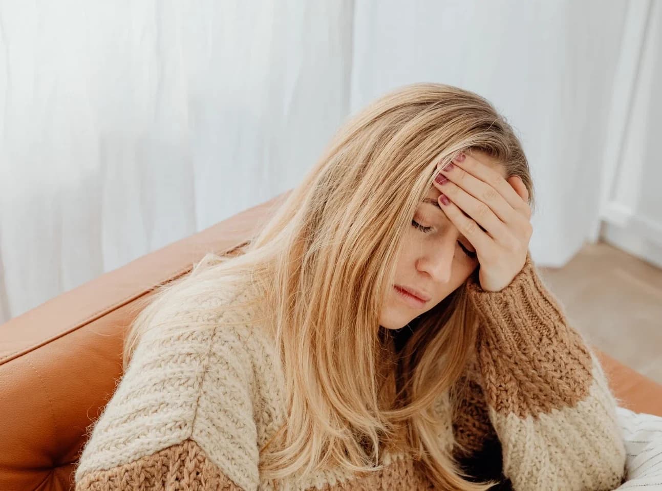 A tired woman resting her head in her hand